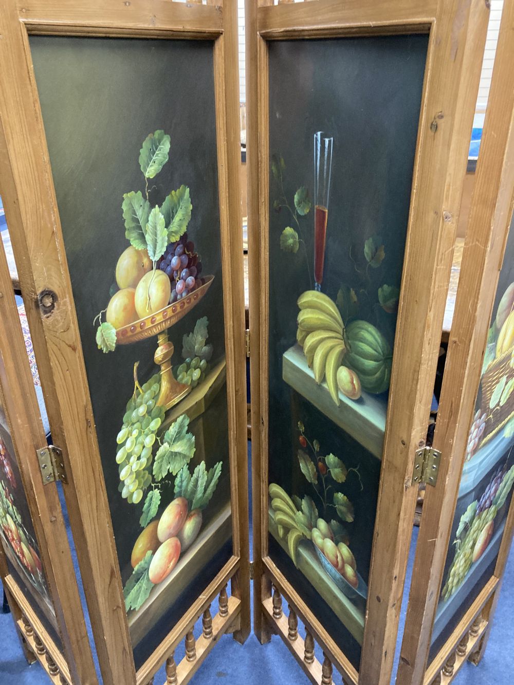 A four fold dressing screen, inset painted panels of fruit, each panel width 45cm height 185cm